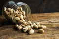 Pistachios scattered on the wooden vintage table from a jar. Pistachio is a healthy vegetarian protein nutritious food