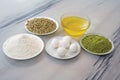 Pistachios, vegetable oil, eggs and flour on plates, Ingredients of sweets in dishes