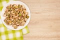 Pistachios in a white plate on a wooden table. Royalty Free Stock Photo