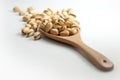 Pistachios in a wooden ladle and placed on a white floor, selective focus. Royalty Free Stock Photo