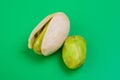 pistacho abierto con otro fruto al lado sobre fondo verde Royalty Free Stock Photo