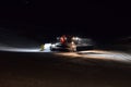 A snow groomer compacting ski runs at night Royalty Free Stock Photo