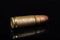 Pistol bullet. Metal case. Old ammunition. Cartridge on a black background. Macro shot of a bullet. Royalty Free Stock Photo