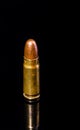 Pistol bullet. Metal case. Old ammunition. Cartridge on a black background. Macro shot of a bullet. Royalty Free Stock Photo