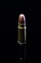 Pistol bullet. Metal case. Old ammunition. Cartridge on a black background. Macro shot of a bullet.