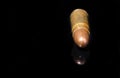 Pistol bullet. Metal case. Old ammunition. Cartridge on a black background. Macro shot of a bullet.