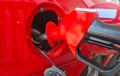 Pistol with fuel in gas tank of red car closeup Royalty Free Stock Photo