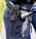 Pistol is holstered on the belt of a policeman in black uniform