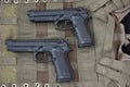 Pistols on a camouflage uniform. Weapon, arms, gun, weaponry, armament, arsenal. Police chains, camouflage, military, war, soldier