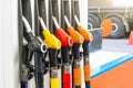Pistols of gasoline fueling cars at the station, against the backdrop of a truck wheel. Royalty Free Stock Photo
