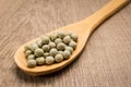 Pea. Spoon and grains over wooden table. Royalty Free Stock Photo