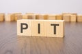 pit text on wooden blocks. wooden background. foreground