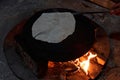 Pita bread baking on a saj or tava on fire, close-up Royalty Free Stock Photo