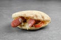 Pita bread with thin sausage, pickled onion, fresh tomatoes and melted cheese