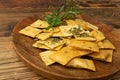 Pita Chips Pile on Wood Plate, Small Wheat Tortillas, Crunchy Flat Bread, Spicy Mediterranean Wheat Snack