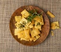 Pita Chips Pile on Wood Plate, Small Wheat Tortillas, Crunchy Flat Bread, Spicy Mediterranean Wheat Snack