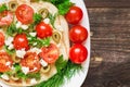 Pita with hummus, cheese, cherry tomatoes, olives and greenery