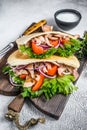 Pita sandwich with roasted chicken, vegetables and delicious sauce. White background. Top view Royalty Free Stock Photo