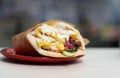 Pita souvlaki cooked for lunch in Greek restaurant. Traditional street food meal cooked on grill and served on plate Royalty Free Stock Photo