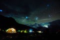 Pitched tents camping at the base of Mount Kilimanjaro at night under the stars