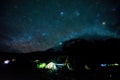 Pitched tents camping at the base of Mount Kilimanjaro at night under the stars