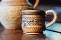 Pitcher and Cup of red clay with Ukrainian ornament on the wooden table Royalty Free Stock Photo