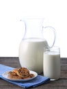 Pitcher and glass with some milk and cookies