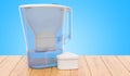 Pitcher water filter with cartridge on the wooden table. 3D rend