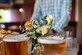 Pitchers of beer and fresh flowers on a restaurant table