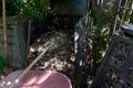 A pitchfork is lying in a compost bin waiting to be used