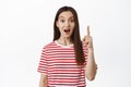 Pitching an idea. Excited young woman has suggestion, pointing up, raising finger and say suggestion, looking amazed Royalty Free Stock Photo