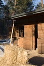 Pitchwork in hay and horse looking from stable