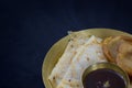 pithe or rice flour dumplings with coconut fillings being served on a plate with date palm jaggery. patishapta or malpoa are