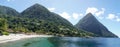 The Piton mountains Gros Piton and Petit Piton in a lush green forest next to the blue ocean on Saint Lucia Island in the Caribbea