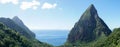 The Piton mountains Gros Piton and Petit Piton in a lush green forest next to the blue ocean on Saint Lucia Island in the Caribbea