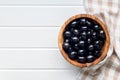 Pitted black olives in wooden bowl on kitchen table. Top view Royalty Free Stock Photo