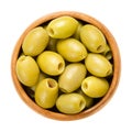 Pitted and marinated green olives in wooden bowl
