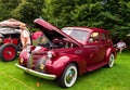 A maroon colored antique car