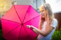 Pity blonde child with pink umbrella under the summer rain with su. Girl enjoying rainfall. Kid playing on the nature Royalty Free Stock Photo