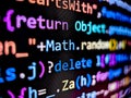 Pixelated view of computer code displayed on a laptop screen with bright colorful characters on dark background