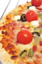 Pizza with bacon, olives, cherry tomatoes, goat cheese, green pe