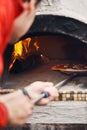 Pizza baking on the deck of a wood-fired oven. The process of making homemade pizza. The concept of homemade fast food. Royalty Free Stock Photo