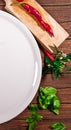 Pizza board with a napkin on white wooden table. Top view vertical mock up. A round white plate on a wooden table with a Royalty Free Stock Photo