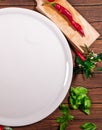 Pizza board with a napkin on white wooden table. Top view vertical mock up. A round white plate on a wooden table with a Royalty Free Stock Photo