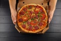 Pizza in box open. Pizza in the in delivery box against a dark background