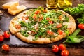 Pizza Caprese with arugula, cheese, yoghurt and cherry tomatoes