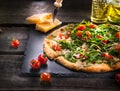Pizza Caprese with arugula, cheese, yoghurt and cherry tomatoes