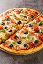 Pizza capricciosa with white mushrooms, ham, artichoke, tomatoes, olives, parmesan and mozzarella on wooden board. Vertical Royalty Free Stock Photo