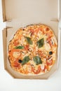 Pizza in a cardboard box on a white table background. Top view. Copy, empty space for text Royalty Free Stock Photo