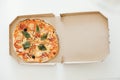 Pizza in a cardboard box on a white table background. Top view. Copy, empty space for text Royalty Free Stock Photo